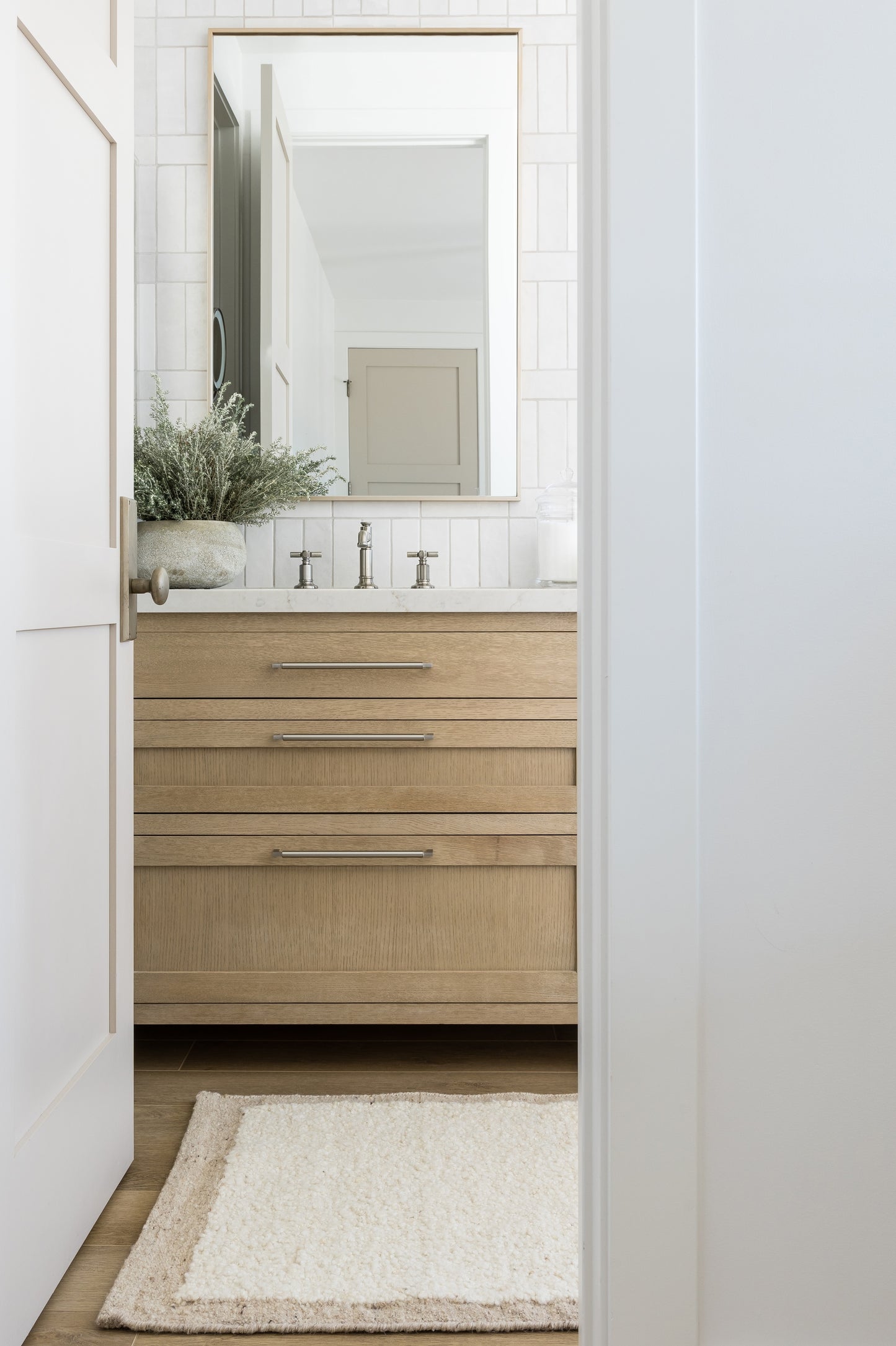 Fluffy beige area rug on a bright bathroom floor.