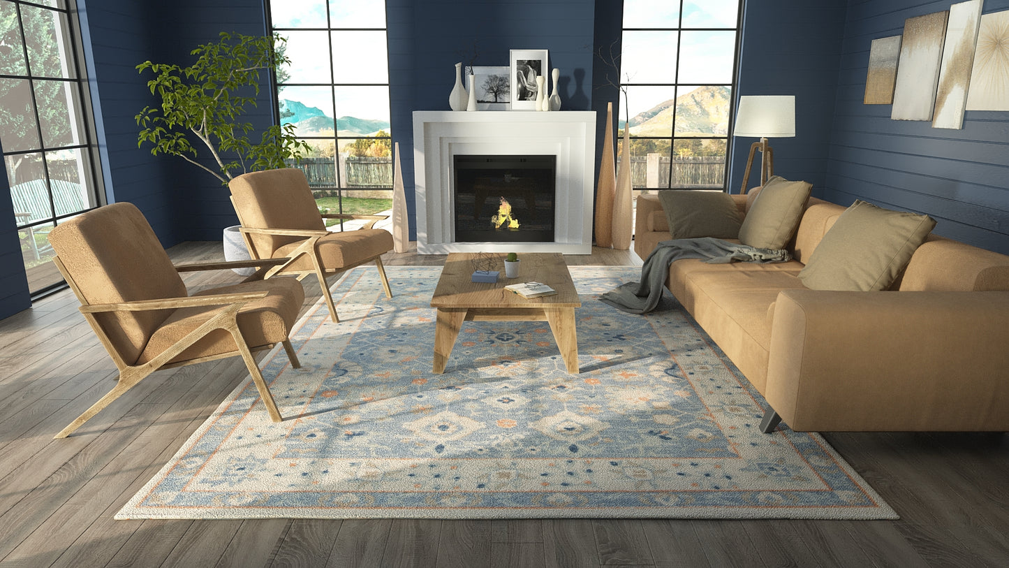 Blue-walled modern living room with tan mid-century chairs, beige sofa, light wood coffee table, patterned rug, fireplace