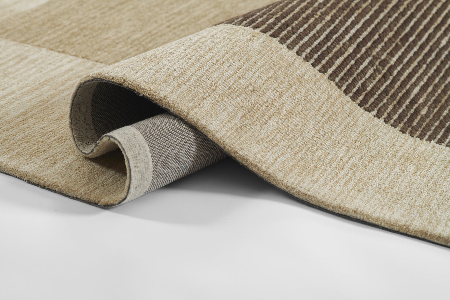 Beige and brown striped woven area rug, rolled edge reveals gray backing and textured pile.