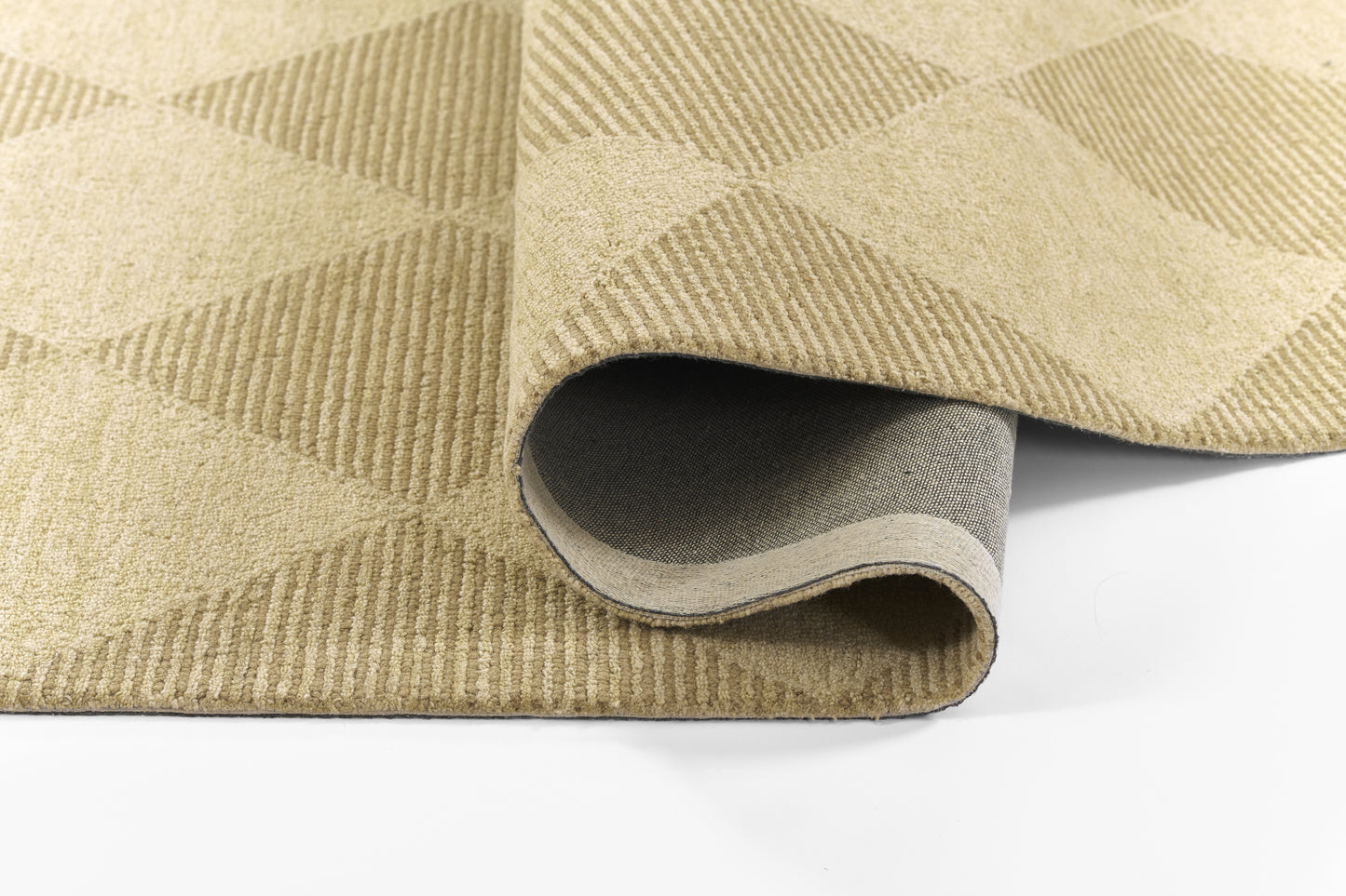 Beige geometric area rug with a diamond pattern, rolled edge showing underside; neutral, soft-textured rug for living spaces.