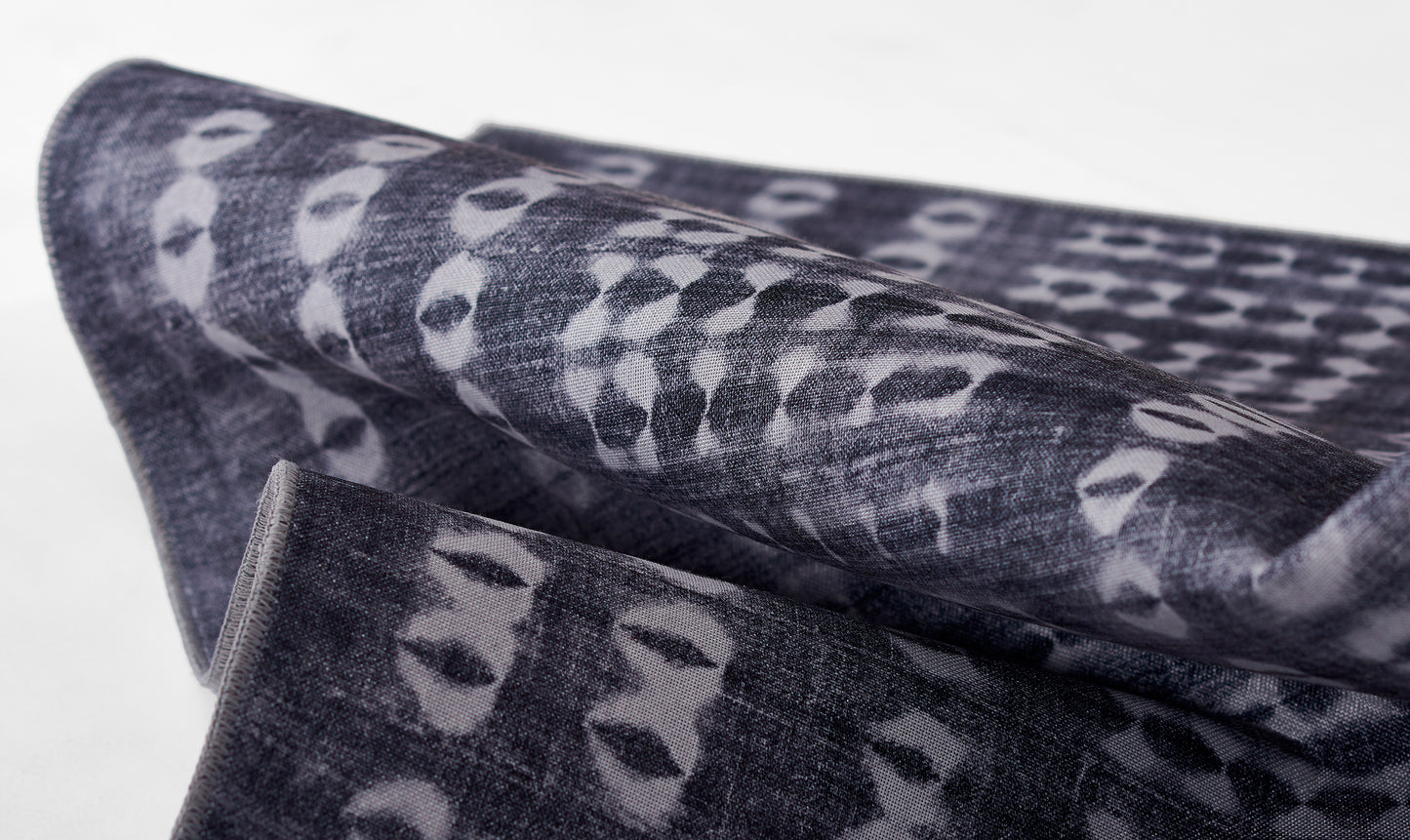 Dark indigo woven fabric with pale gray irregular spots, folded textile suitable as scarf or throw.