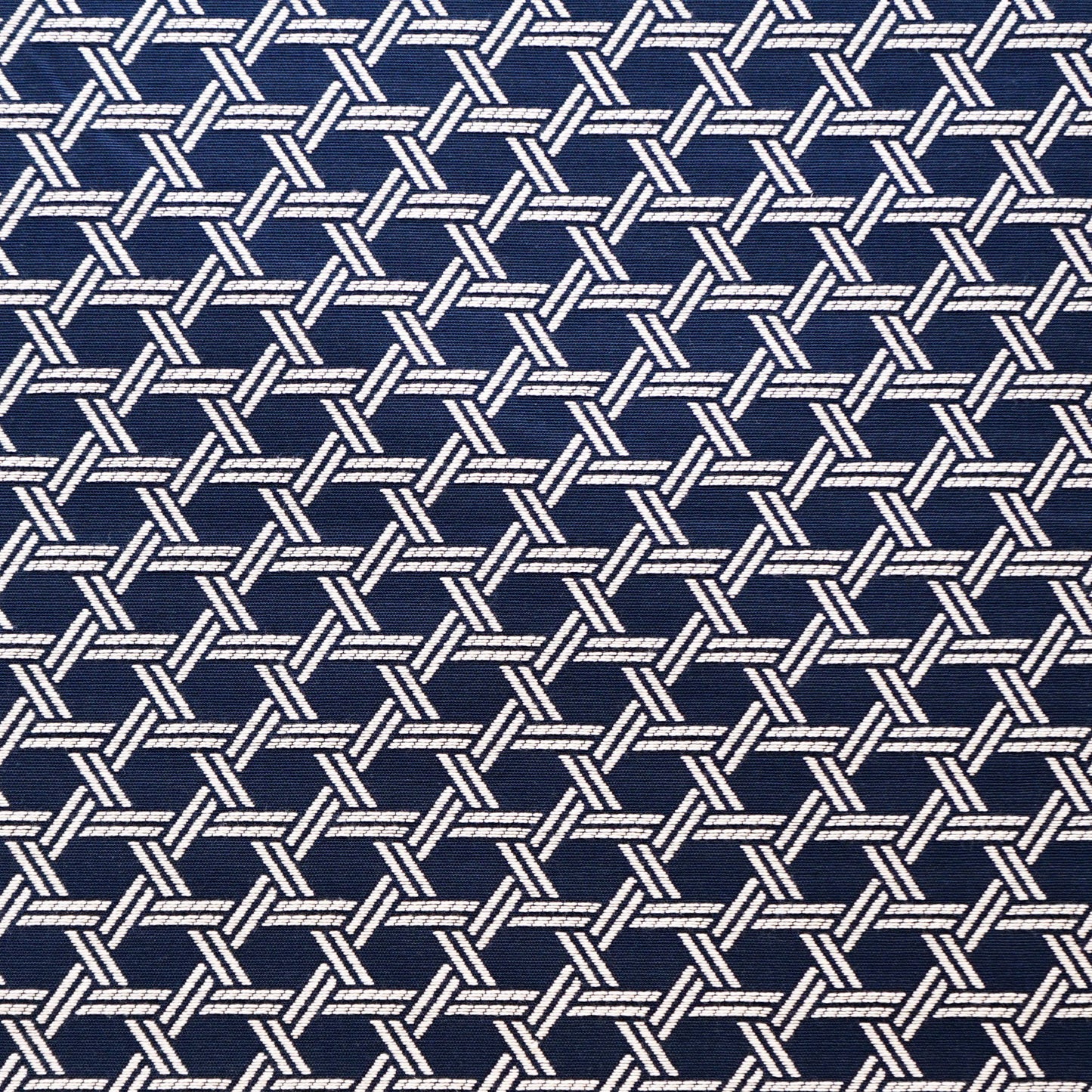 Navy fabric with repeating white braided lattice pattern; rope-like interlocking motif.
