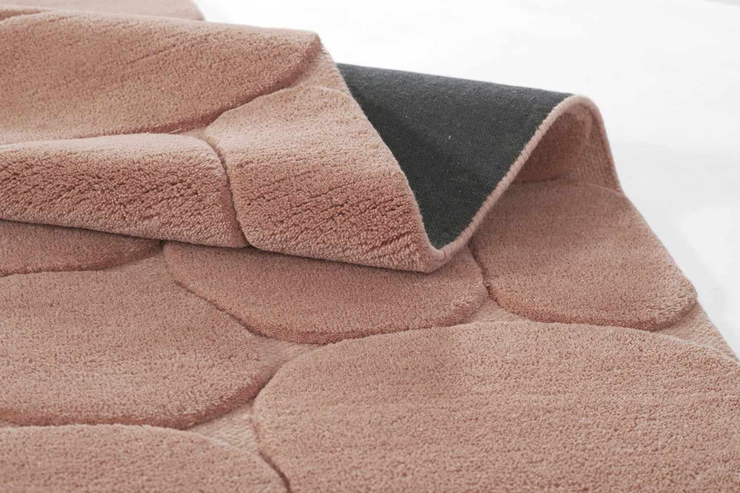 Soft blush pink plush blanket with a dark gray underside, quilted panel texture, cozy throw.