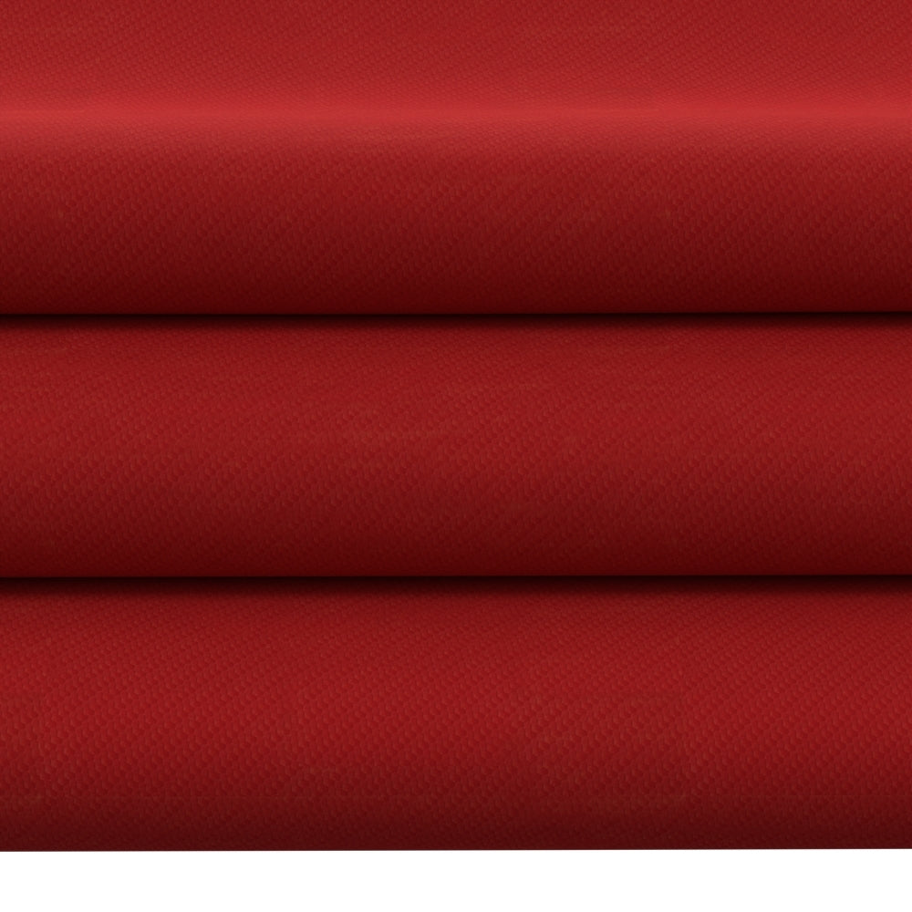 Red textured upholstery fabric rolls with a woven pattern, deep crimson color, stacked layers.