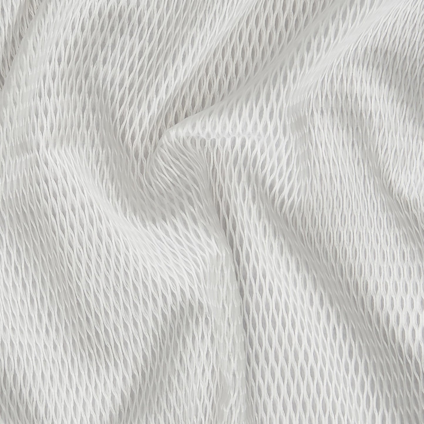 Close-up of creme/off-white sheer mesh fabric with a honeycomb pattern and soft drape.
