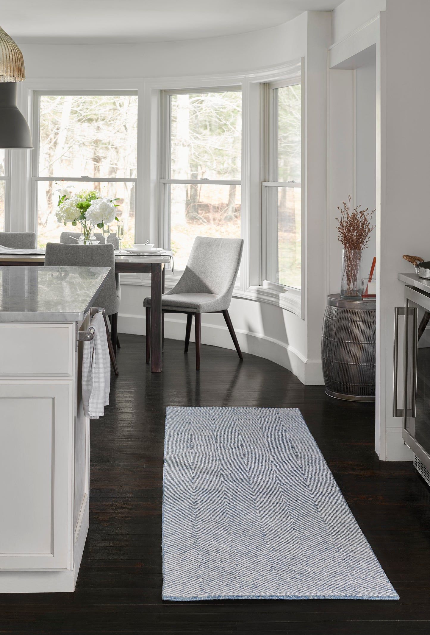 Blue & white chevron runner rug on dark wood floor in bright white kitchen, rectangular, modern farmhouse style.