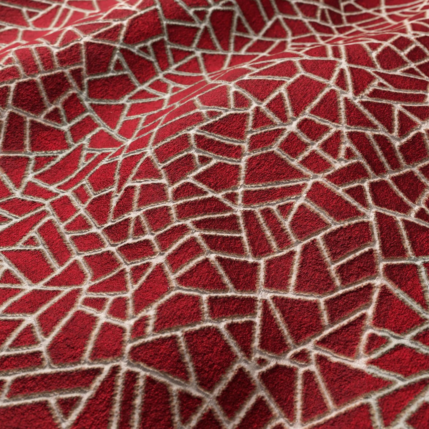 Red velvet fabric with cream cracked-mosaic lines forming irregular geometric shapes; plush textured surface.