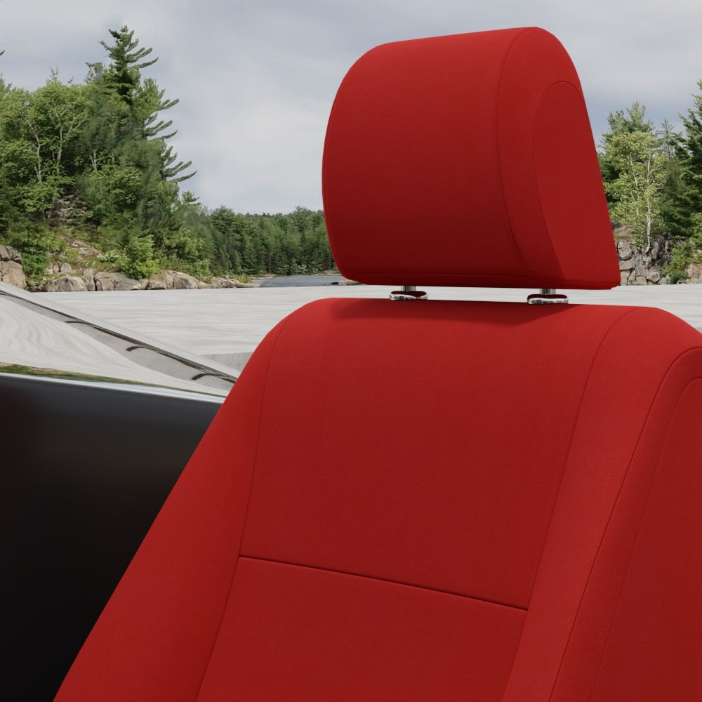 Bright red solid fabric upholstery inside a vehicle, with a forested lakeside scene visible outside