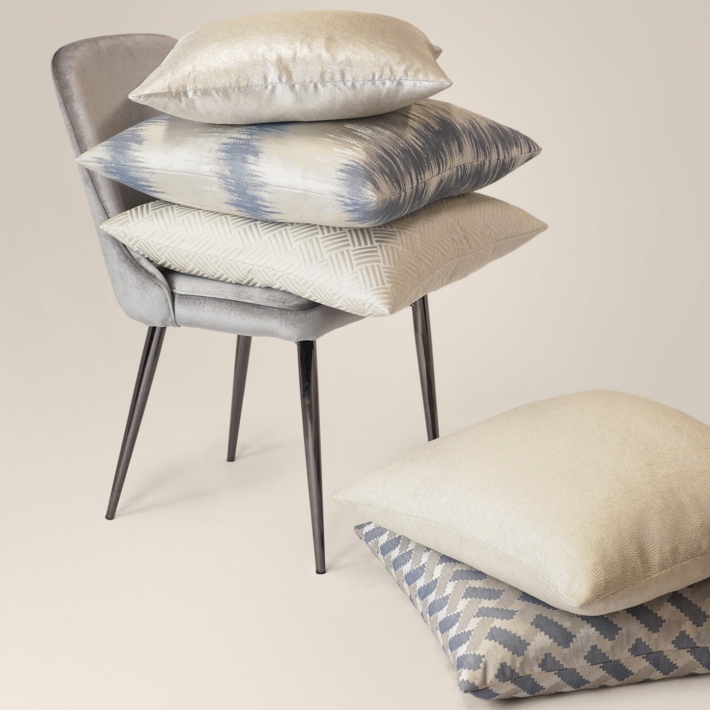 Ivory solid abstract pillow on a gray chair.