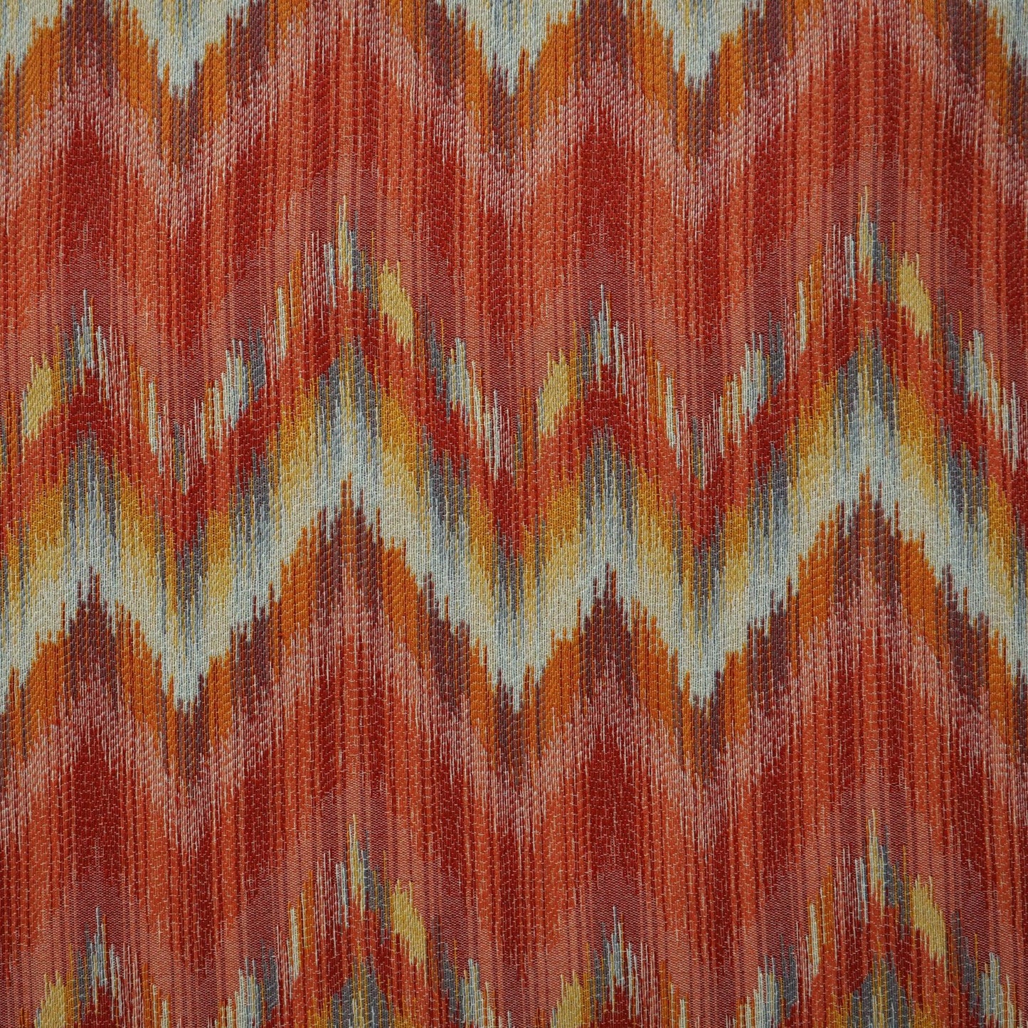 DANCETTE 24 fabric with flamestitch pattern in blue, burgundy, red, creme, beige, orange, rust, pink, purple, yellow, gold on a cream background.
