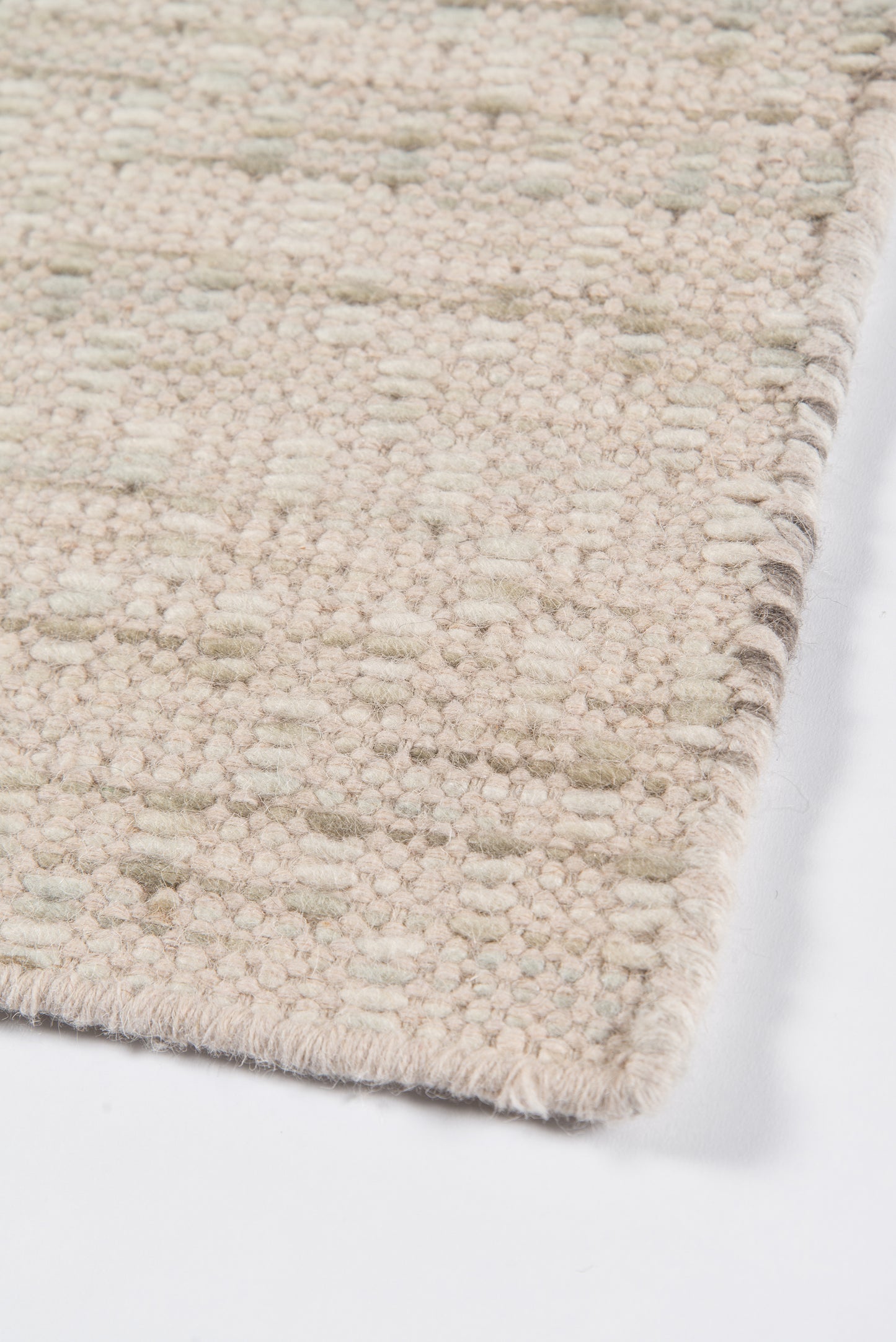 Cream textured woven rug with looped pile and subtle geometric dots; rectangular, soft plush for living rooms.