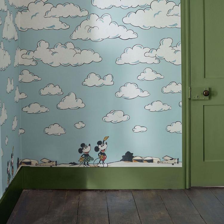 Disney Home x Sanderson Mickey in the Clouds wallpaper mural featuring Mickey Mouse flying through soft pastel clouds and airplanes in a whimsical vintage sky design. Classic Disney nursery wallpaper ideal for kids bedrooms, playrooms, and Disney themed interiors. Dreamy cloud wallpaper mural perfect for nursery décor, feature walls, children’s room design, and vintage Disney home styling.