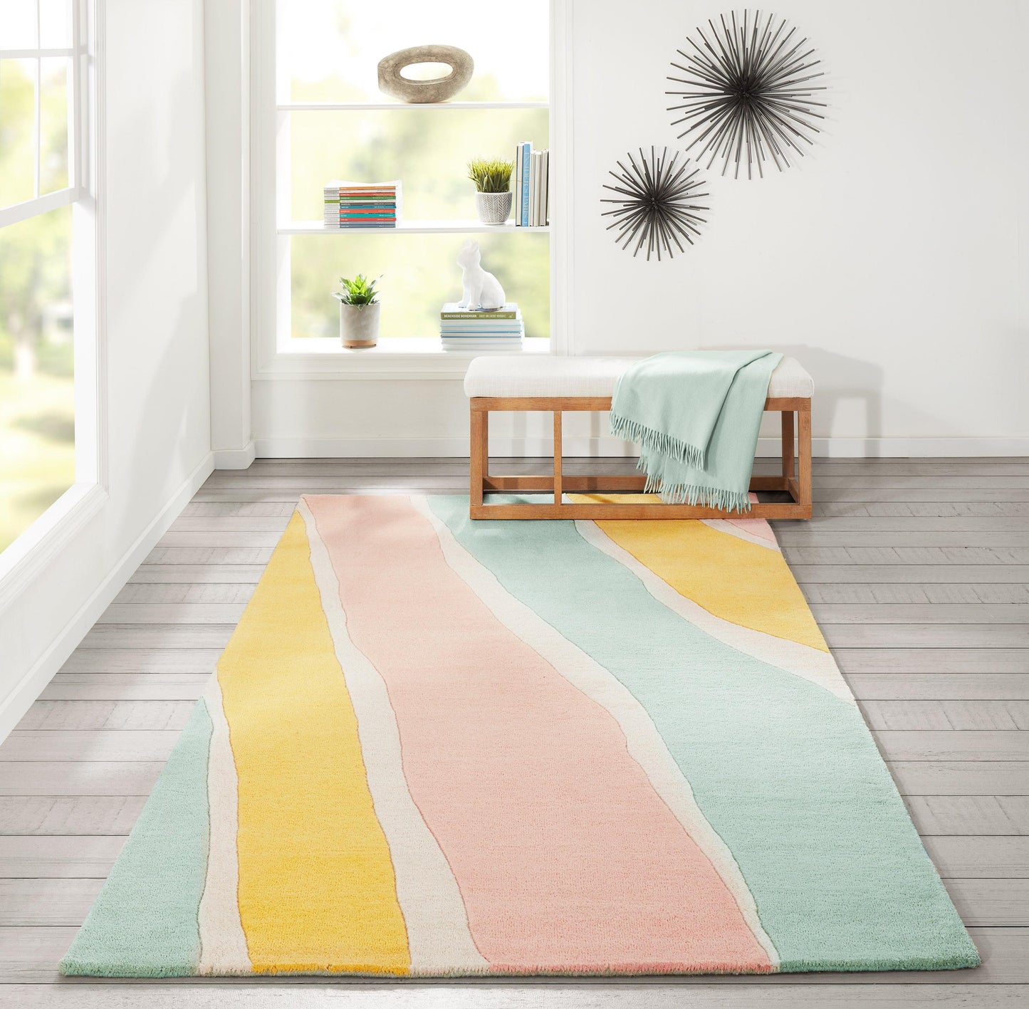 Pastel striped rug with wavy blocks of peach, pink, yellow, mint and teal in a bright living room.