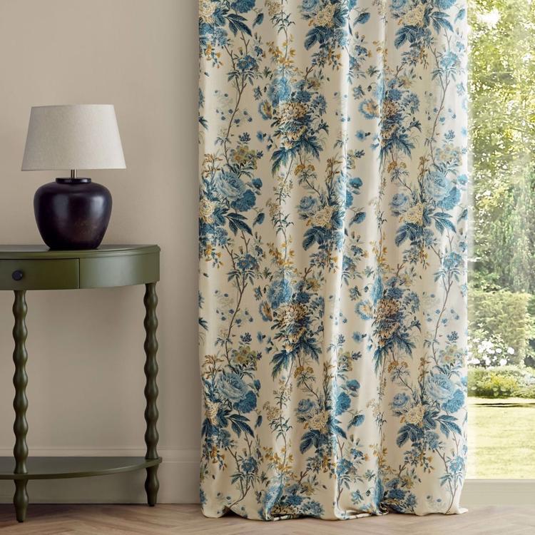 Sanderson Lakeland Paradis fabric in Poppinjay/Lion featuring a classic floral design on an ivory linen background with rich blue, golden yellow, and soft beige botanical details. Premium 100% linen designer fabric perfect for drapes, curtains, upholstery, decorative pillows, cushions, and elegant cottage, traditional, and English-inspired home décor.