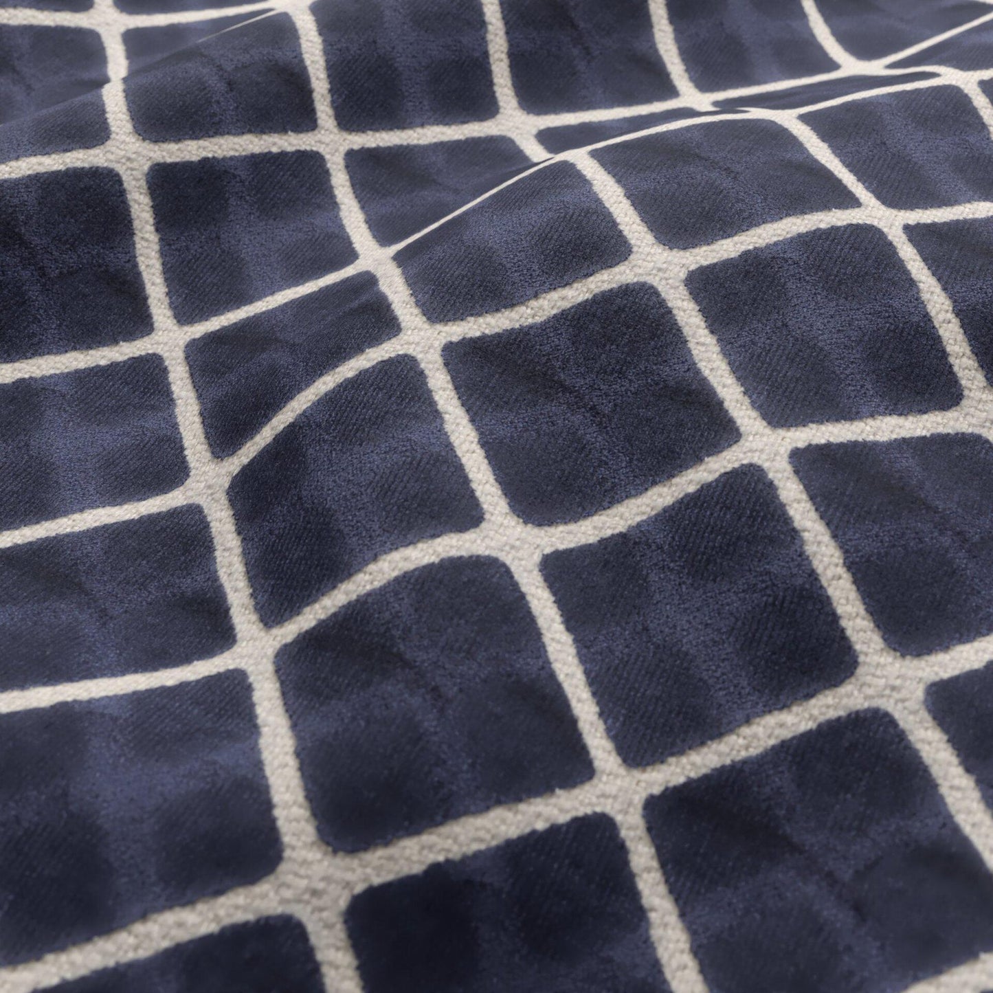 Navy blue velvet fabric with a cream geometric diamond pattern.