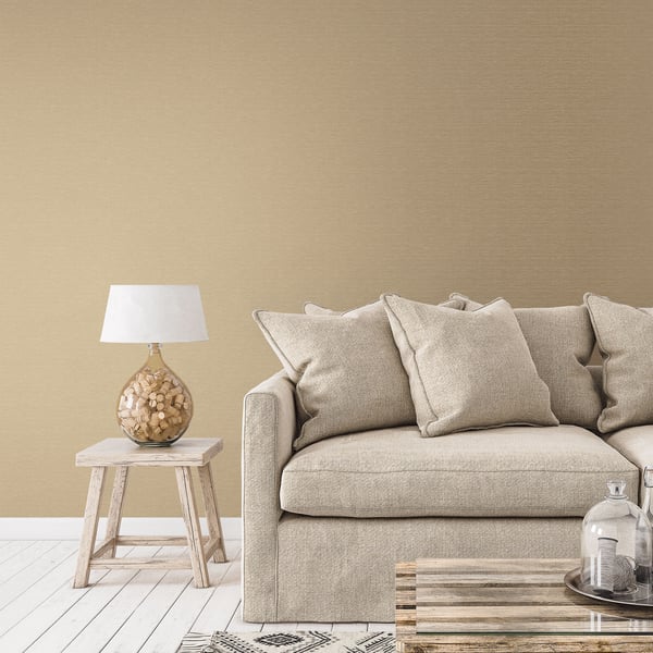 Beige fabric sofa with cushions, light wood side table and cork-textured lamp, glass cloche on a wooden coffee table.