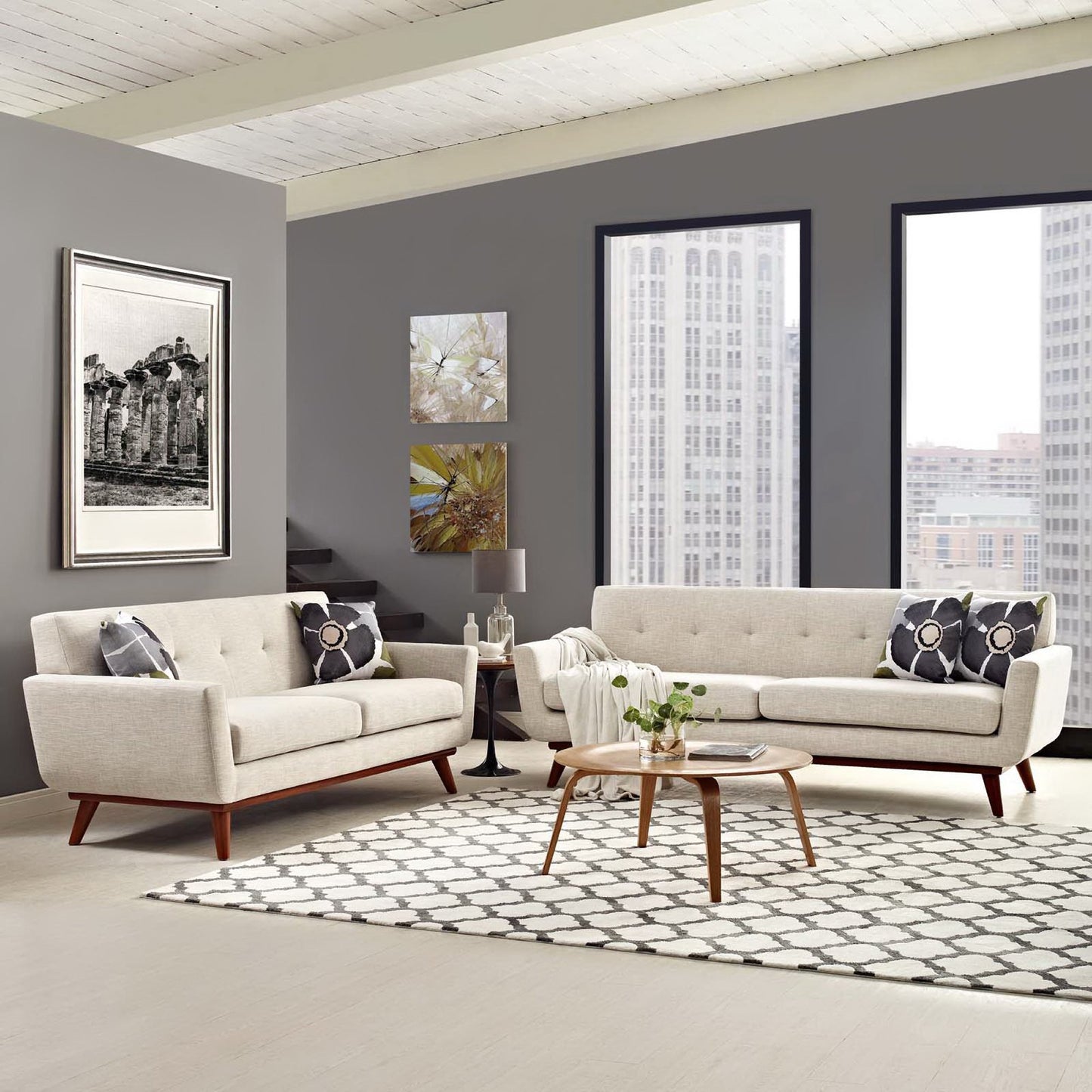 Neutral beige mid-century sofa set with wood legs, round wood coffee table, patterned rug, city view windows.