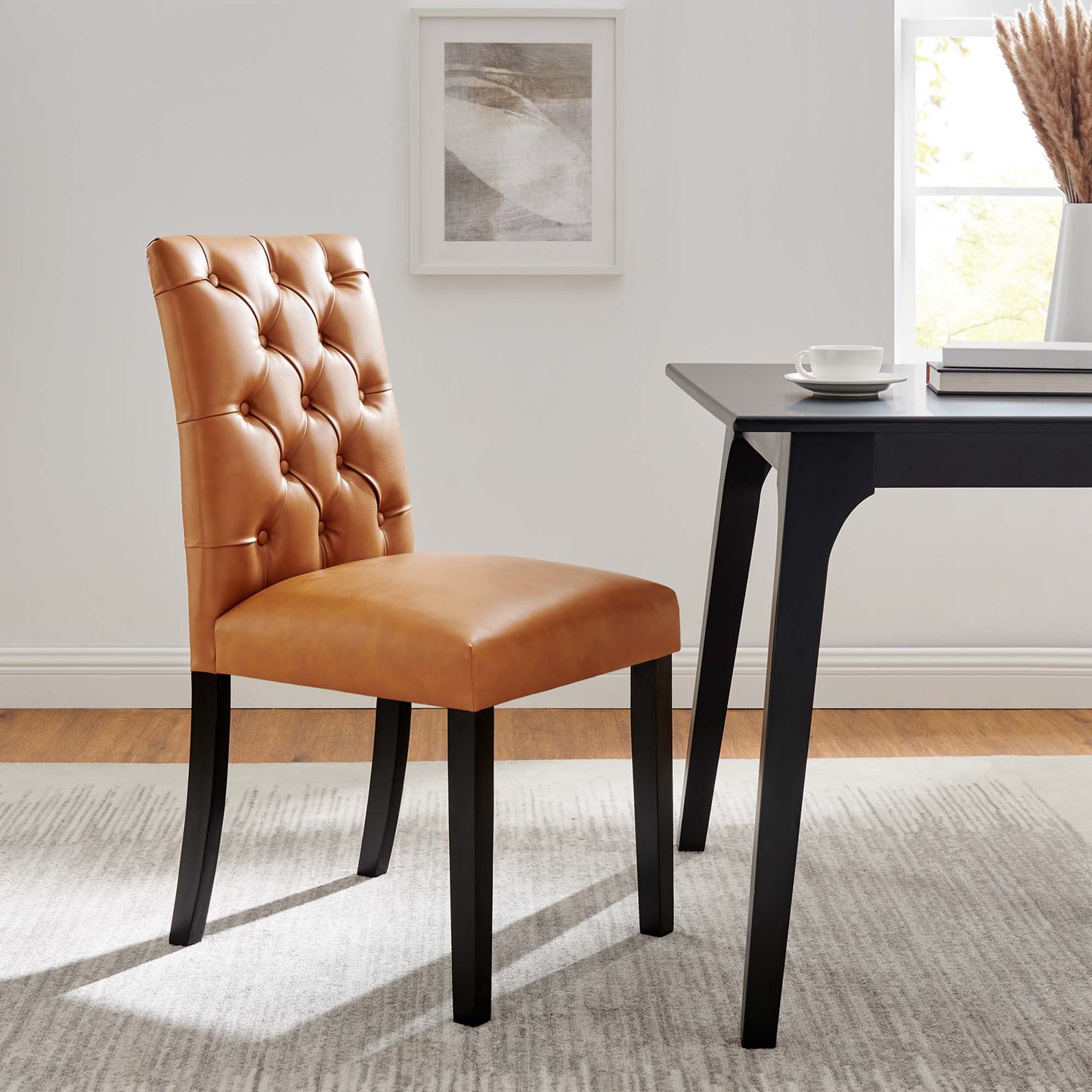 Tan vegan leather, button-tufted dining chair with dark wood legs.