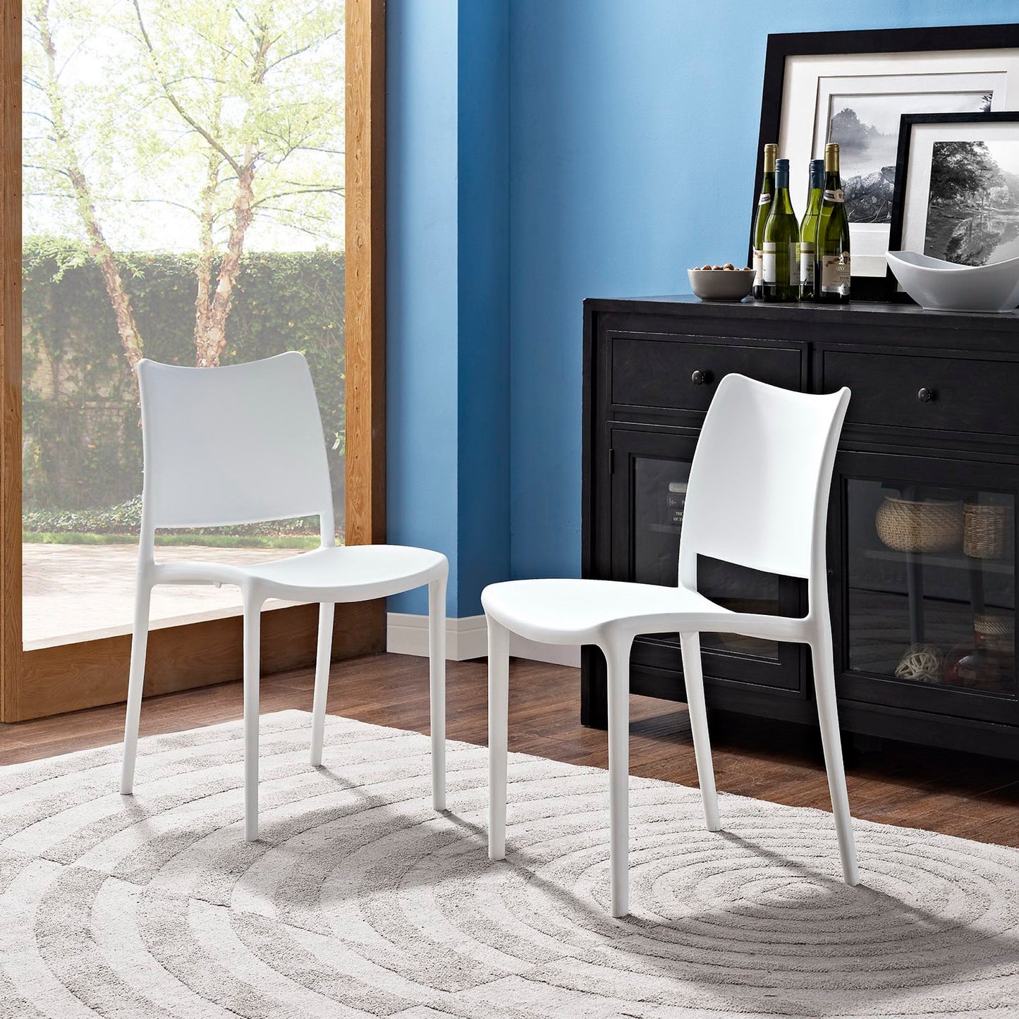 Set of two white modern molded-plastic dining chairs with curved backs and slender legs.