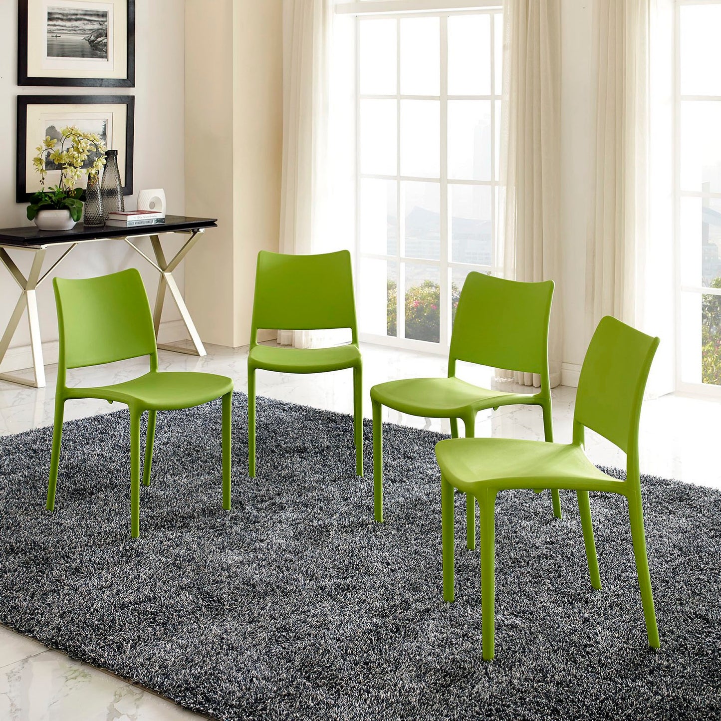 Four lime-green molded plastic dining chairs with metal legs, arranged on a gray shag rug in a bright modern room.