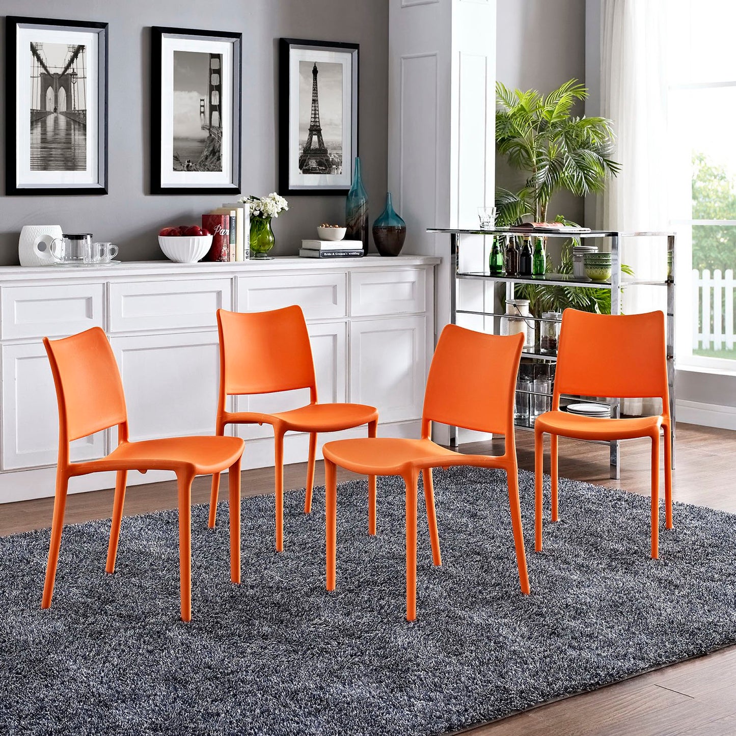 Set of 4 bright orange modern dining side chairs with curved backs on a gray rug in a contemporary dining area.