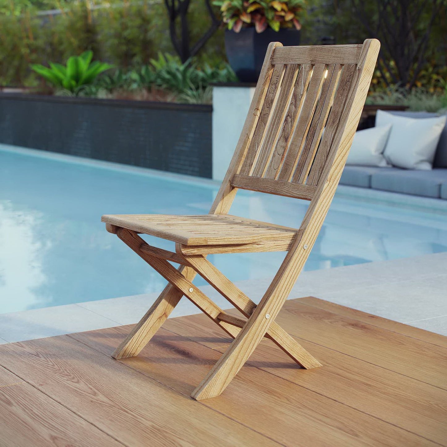 Brown teak folding chair on a poolside deck, outdoor furniture.