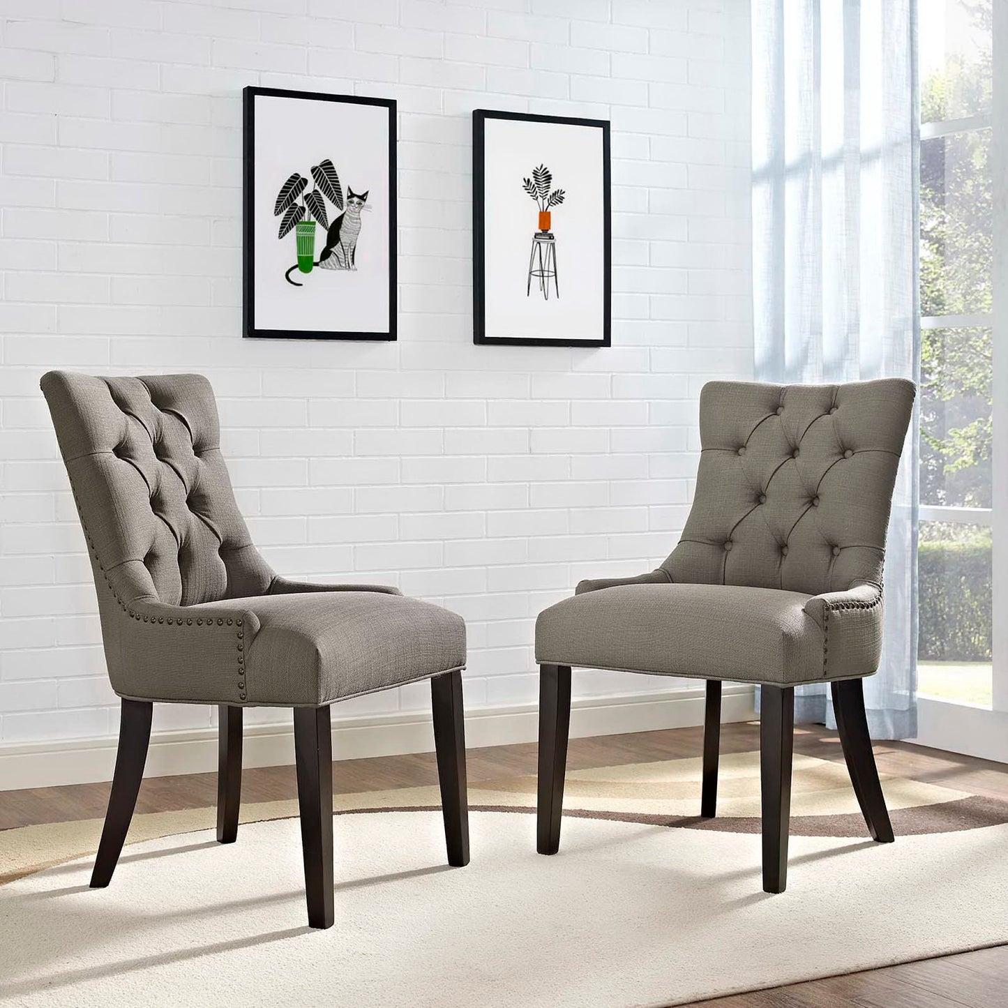 Set of two gray tufted dining side chairs with dark wood legs and nailhead trim.
