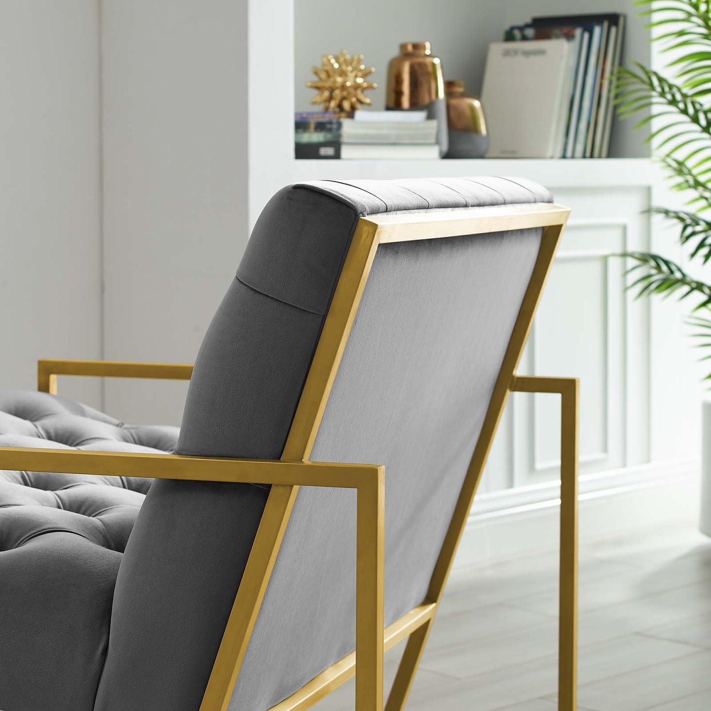 Grey velvet tufted accent chair with a gold metal frame, modern luxe seating.