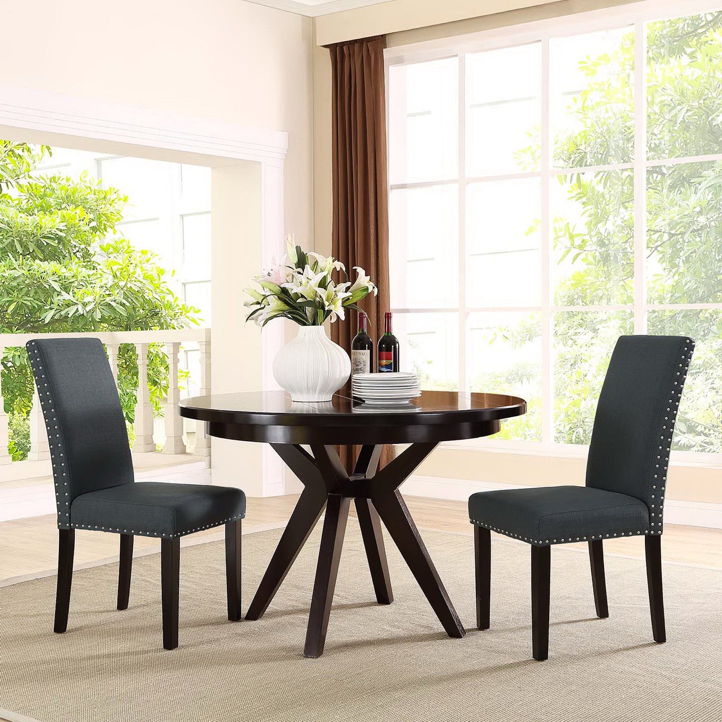 Two gray upholstered dining side chairs with a vase of white flowers.