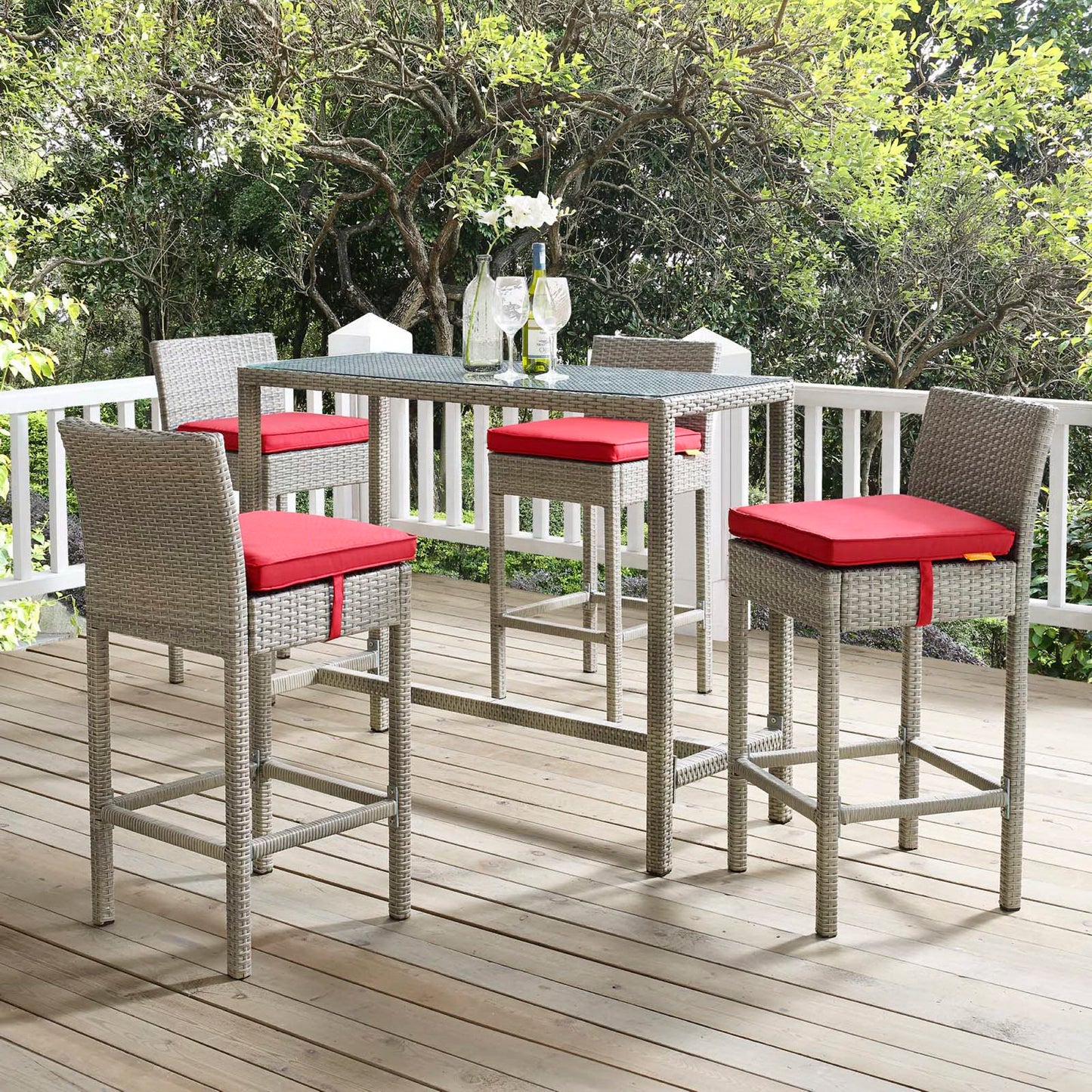 Outdoor wicker bar-height stools set of 4 with red cushion seats on a wooden deck.