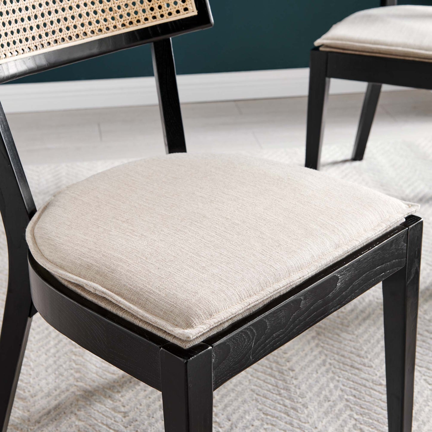 Brown wood dining chair with beige fabric seat cushion and woven cane backrest.