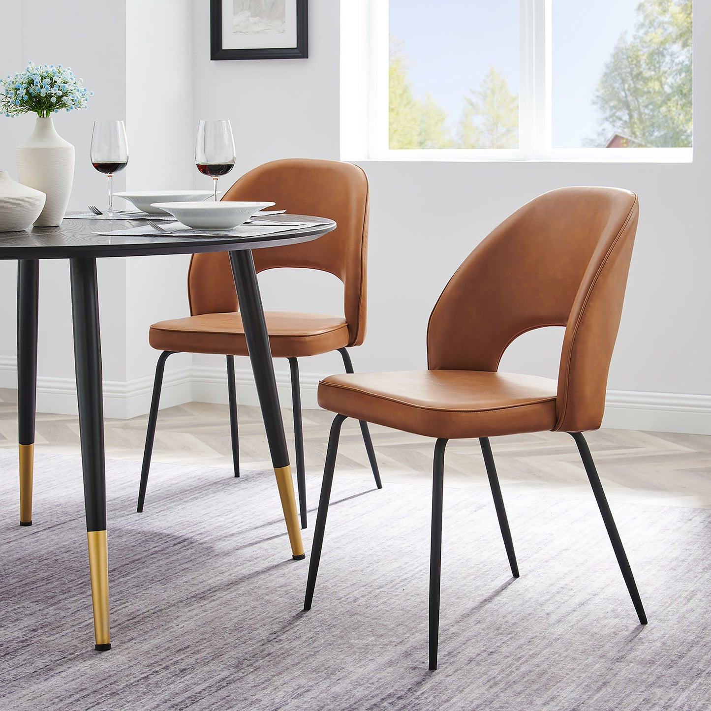 Pair of brown vegan leather dining chairs with gold-tipped legs, modern minimalist dining set.