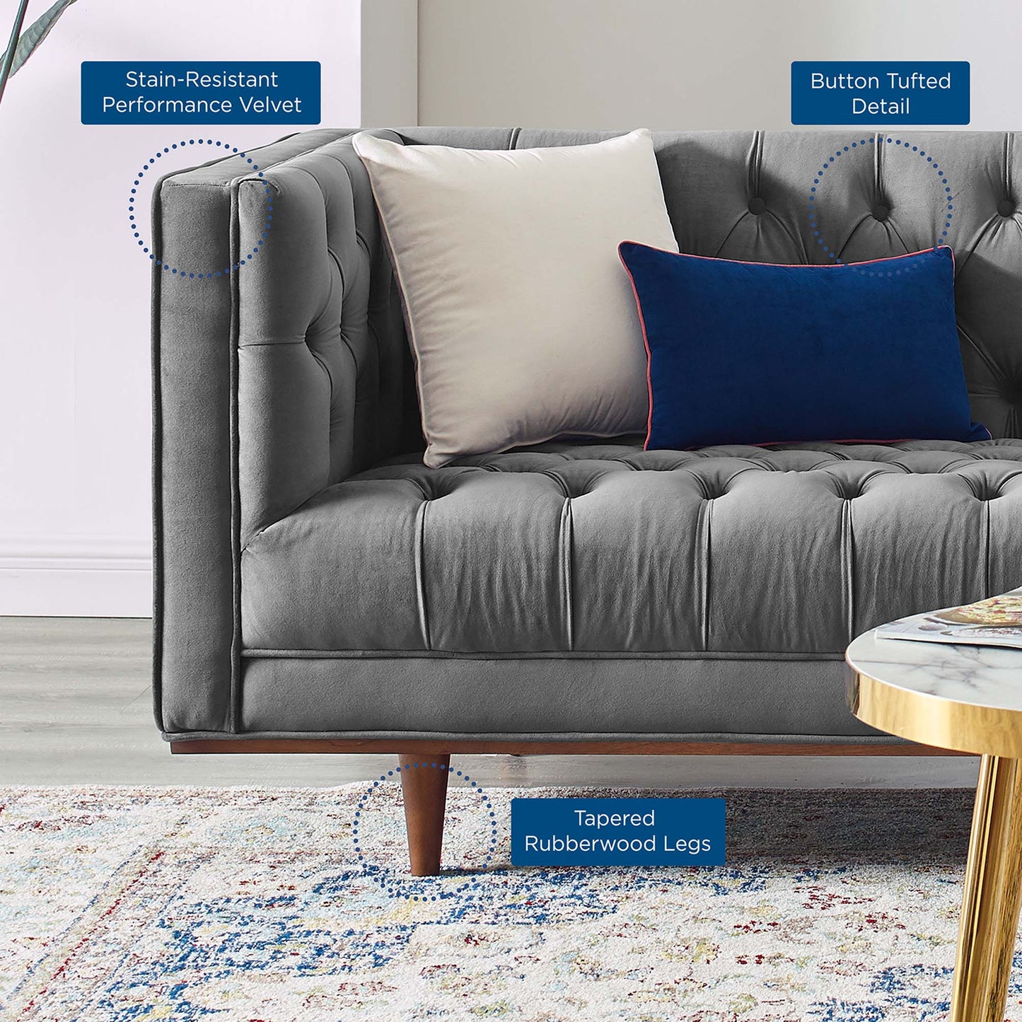 Grey tufted sofa in stain-resistant velvet with cream and blue cushions, tapered rubberwood legs.