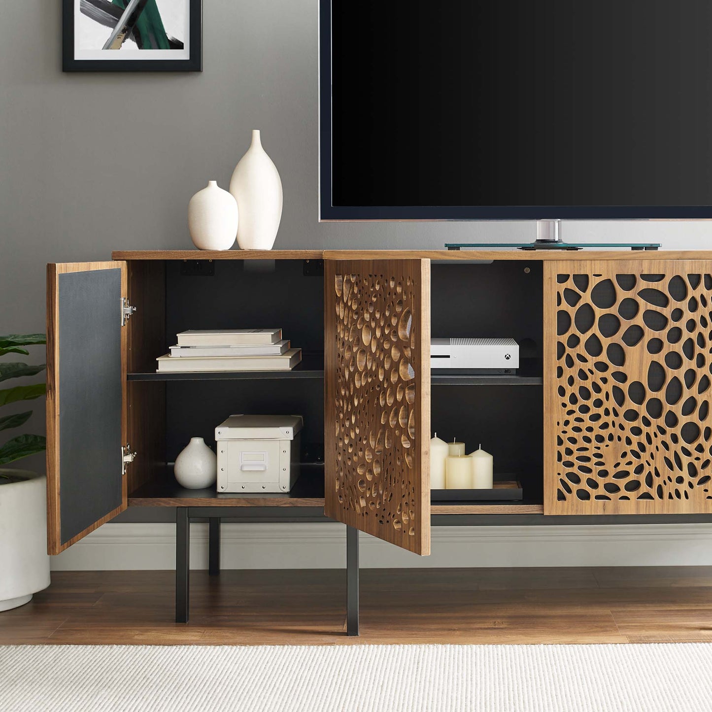 Walnut veneer sideboard with decorative circular perforated doors, black interior, metal legs and storage shelves.