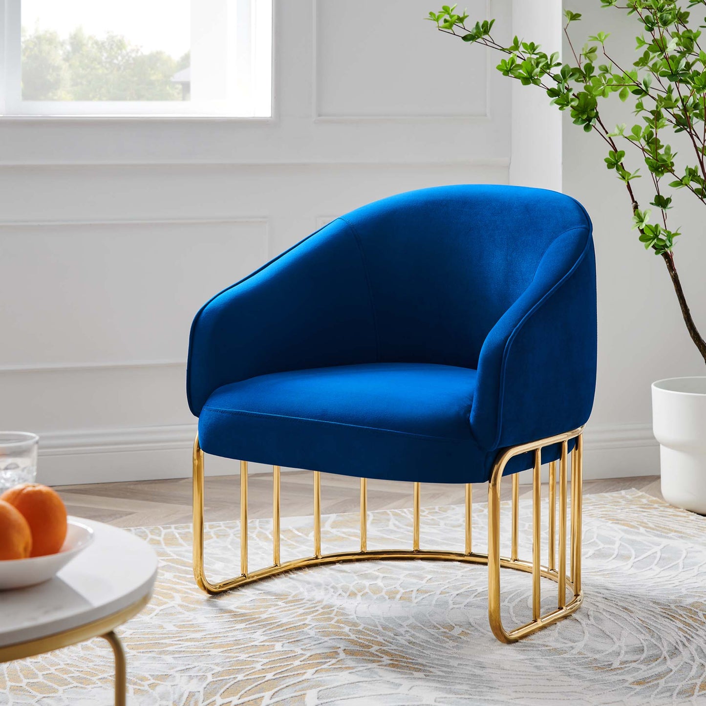 Navy blue velvet accent chair with curved back and arms on a gold metal open-frame base.