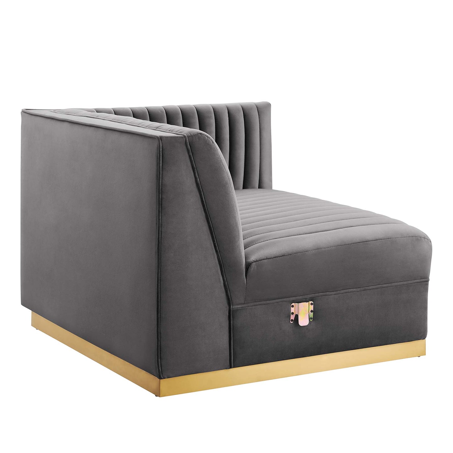 Gray velvet sectional sofa with channel-tufted back, chaise-style seat on the right, low gold metal base, modern contemporary design.