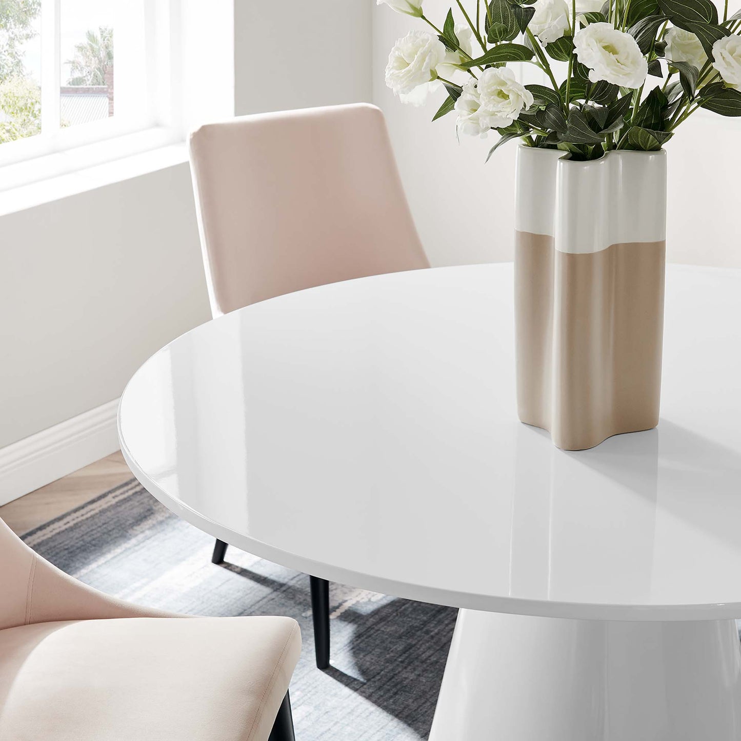 Glossy white 47-inch round dining table with black metal legs.