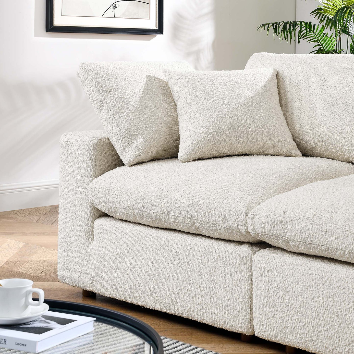 Ivory boucle loveseat with two matching pillows; plush textured fabric, modern cozy living room seating.