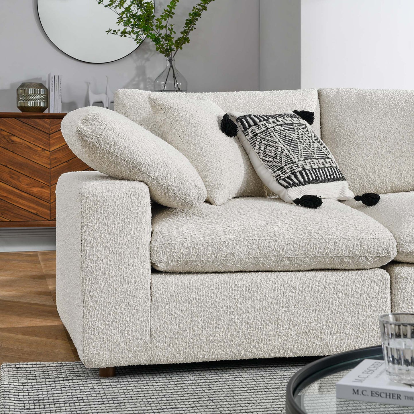 Ivory boucle sectional sofa with rounded arms and plush cushions, featuring a black & white geometric throw pillow.