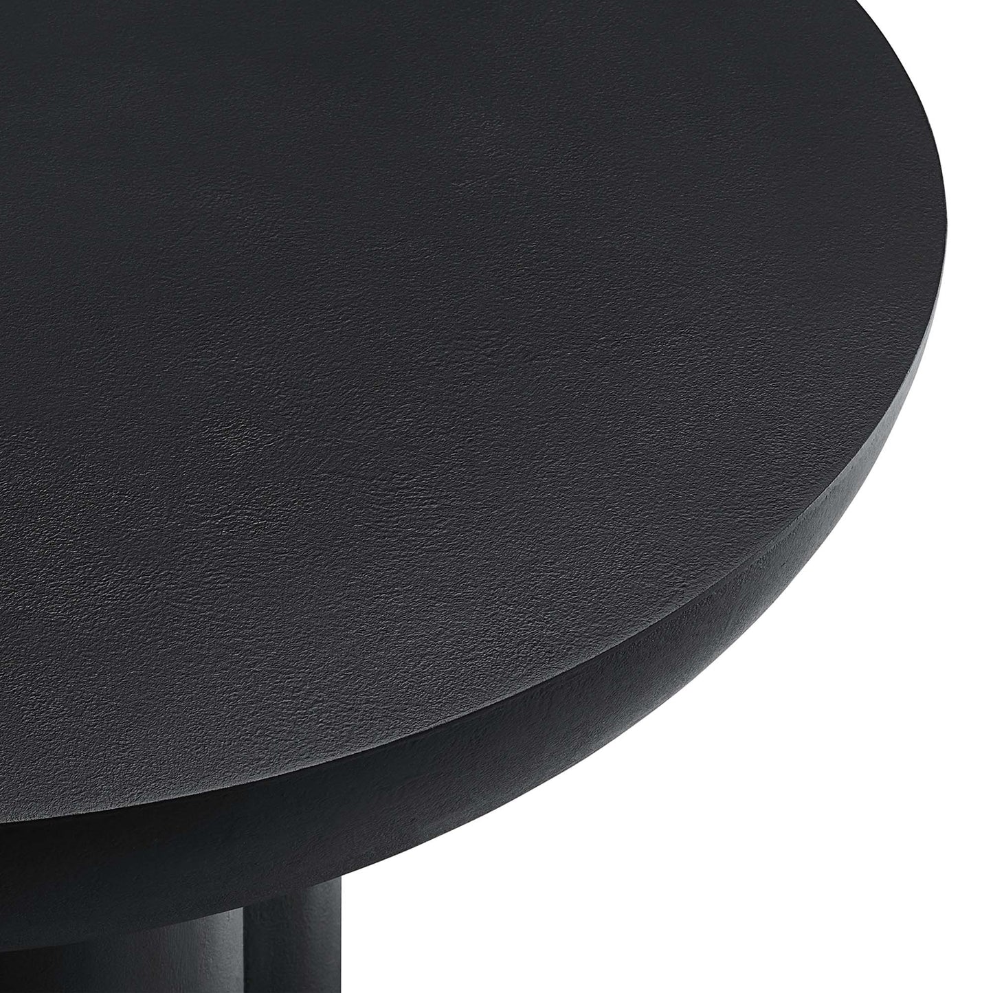 Black round concrete coffee table with a smooth top and visible legs.