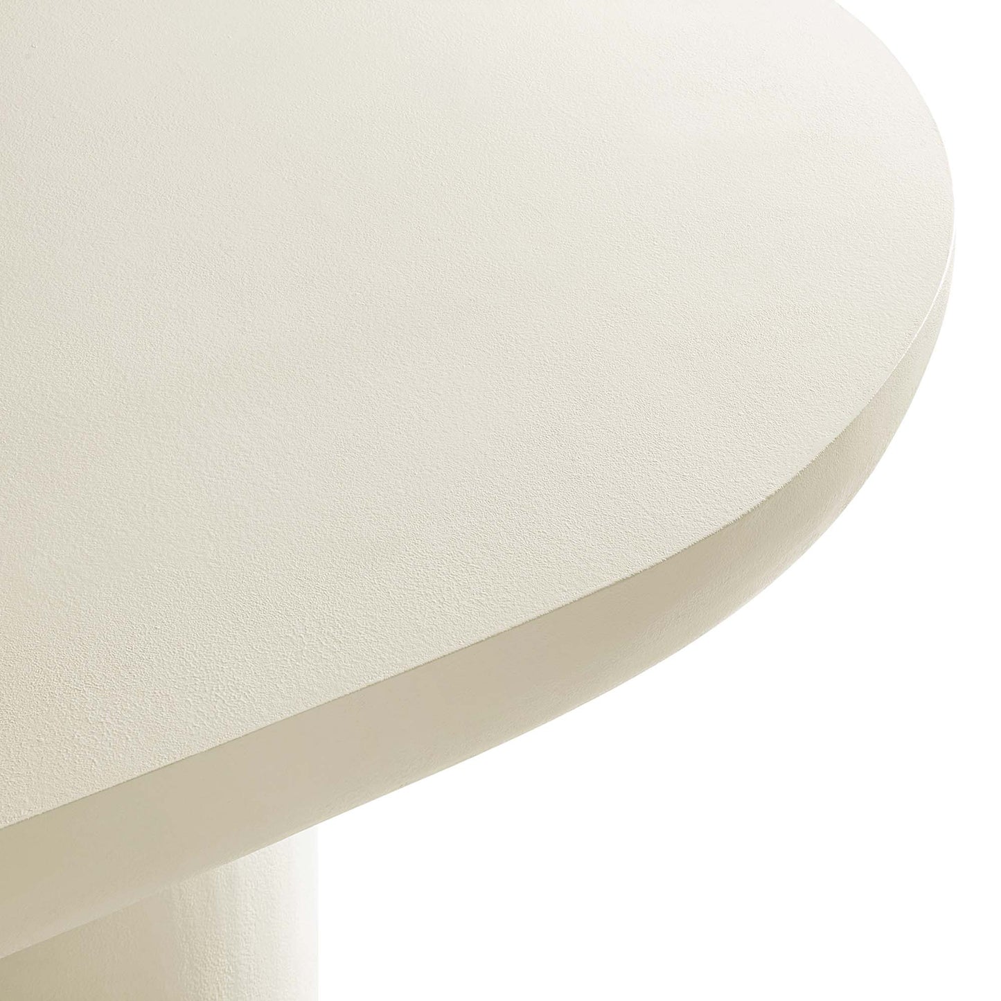Cream-white oval concrete dining table with a textured surface and pedestal base.