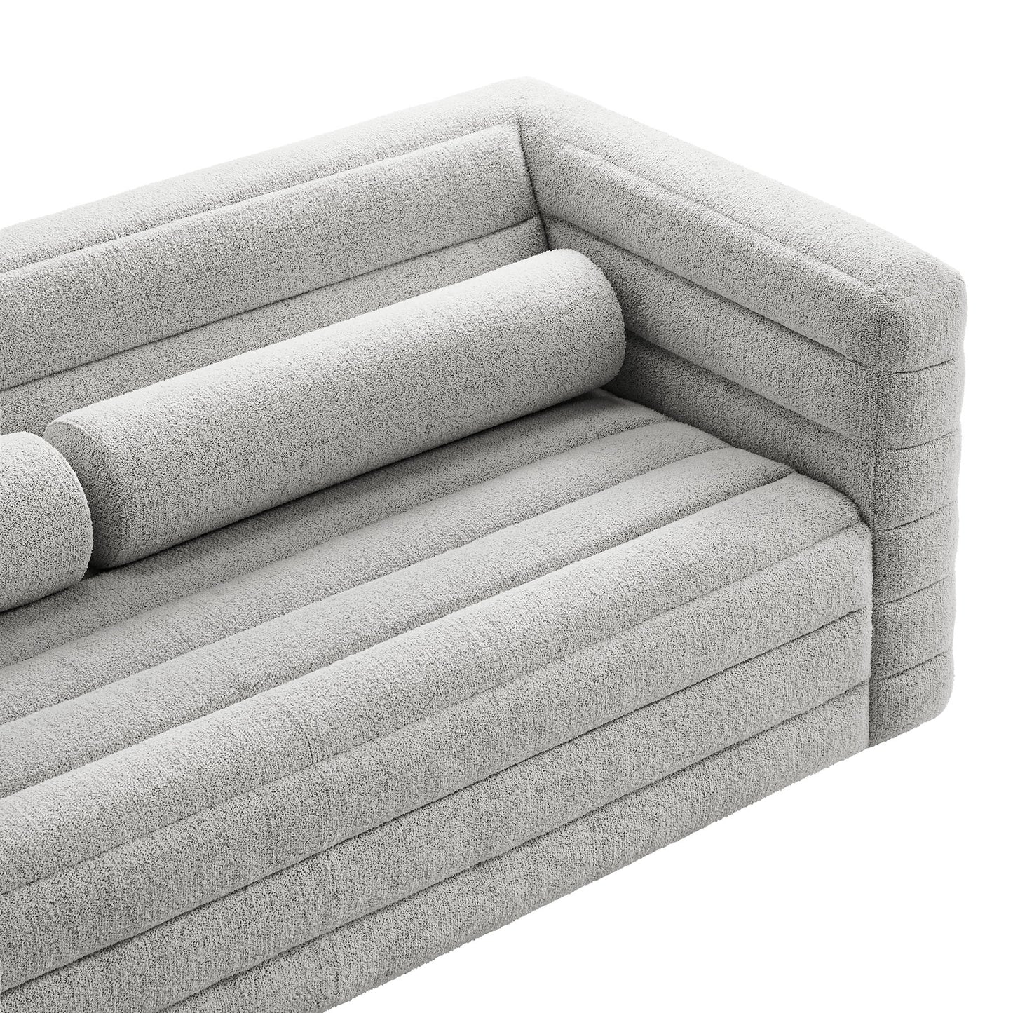 Light gray textured boucle fabric modular sofa with channel-stitched cushions and cylindrical bolster pillow.