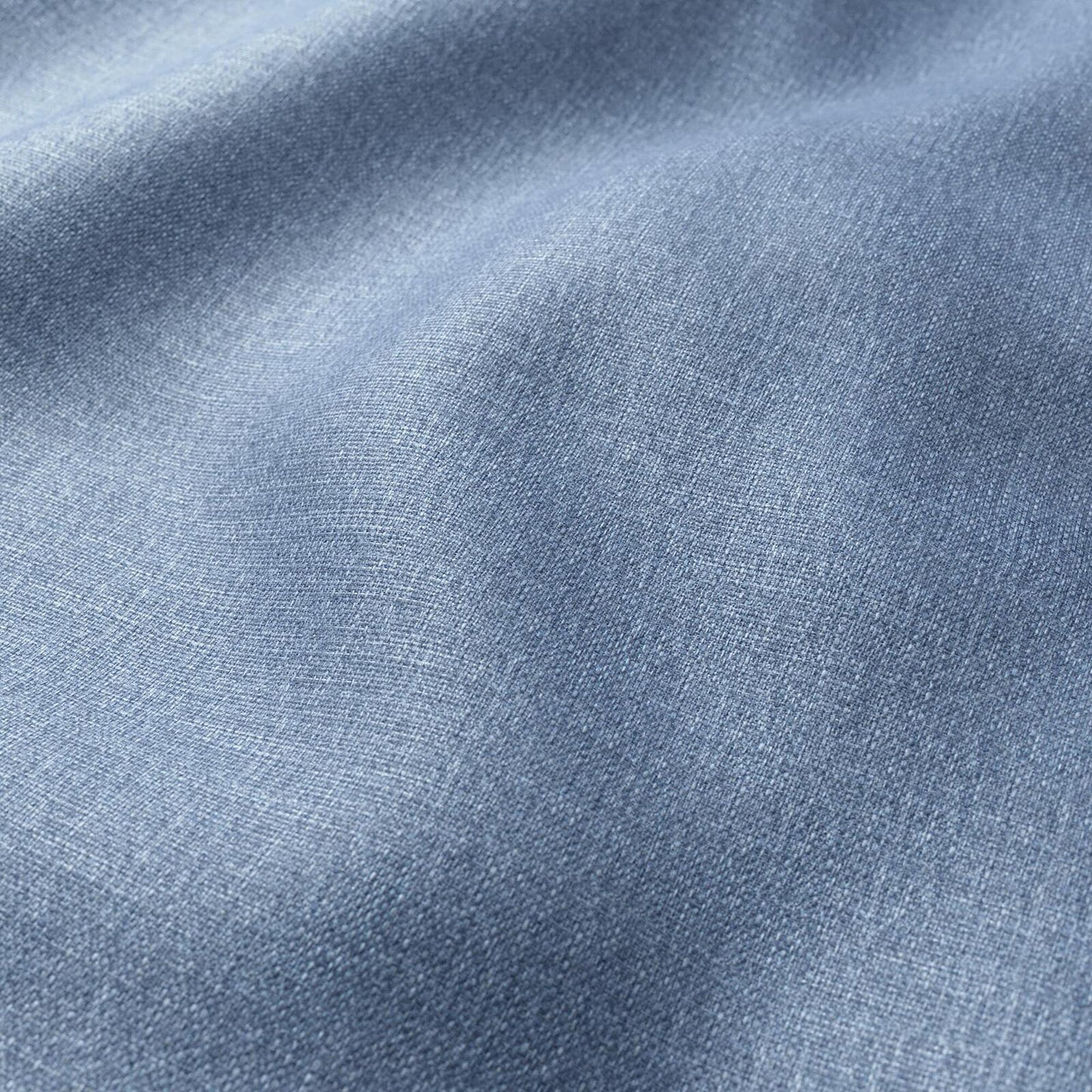 Close-up of light blue denim fabric, showing textured weave and soft folds.