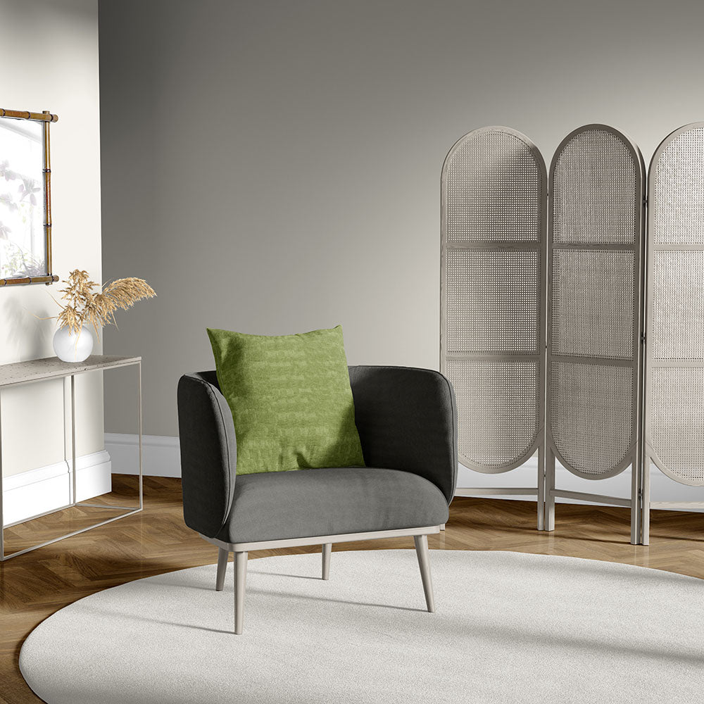 Gray solid fabric upholstery on an armchair with light wood legs and a green cushion in a modern Scandinavian living room with a 3-panel gray divider.