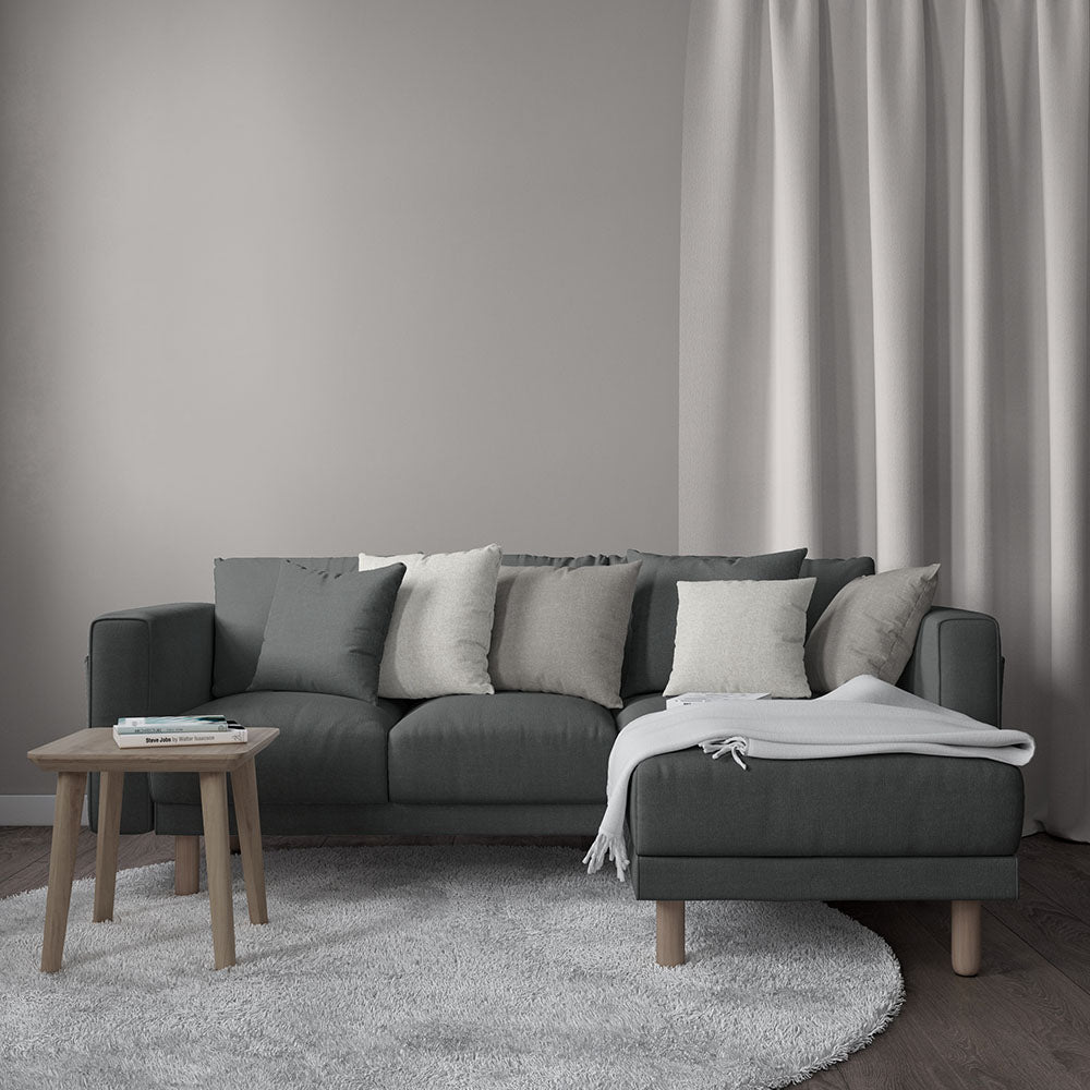 Charcoal fabric sectional with light gray cushions, chaise and throw, metal legs, beige shag rug, small wood coffee table.