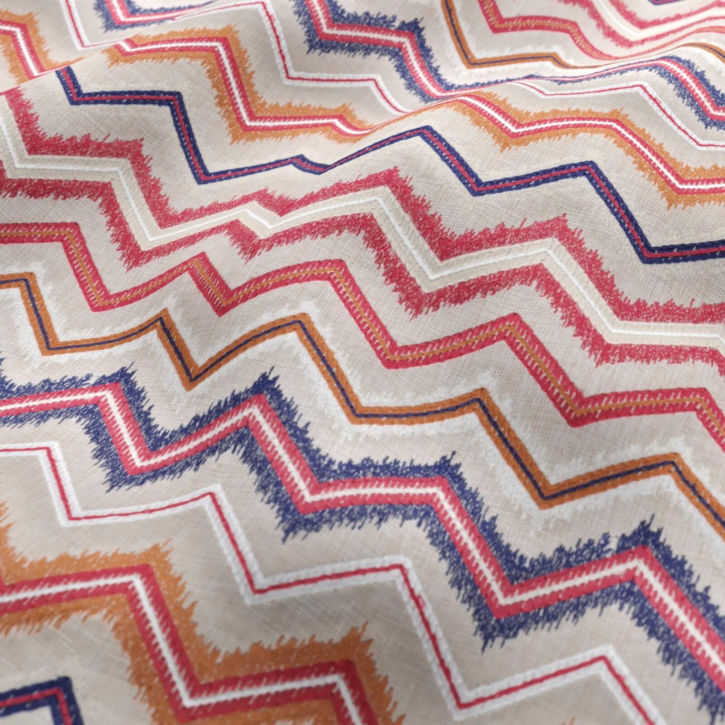 Beige linen-textured woven fabric with a geometric chevron pattern in white, orange, light red and navy.