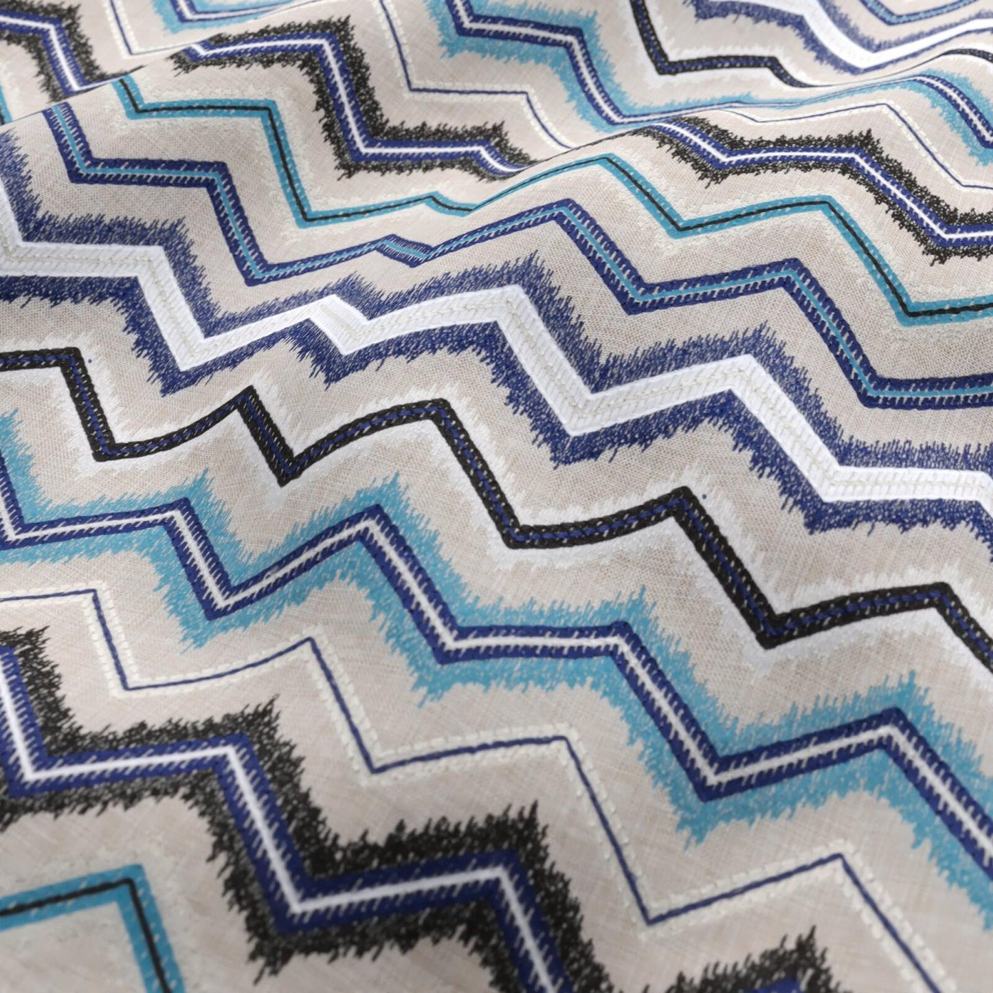 Chevron zigzag fabric in blue, teal, black, and white with textured woven stripes.