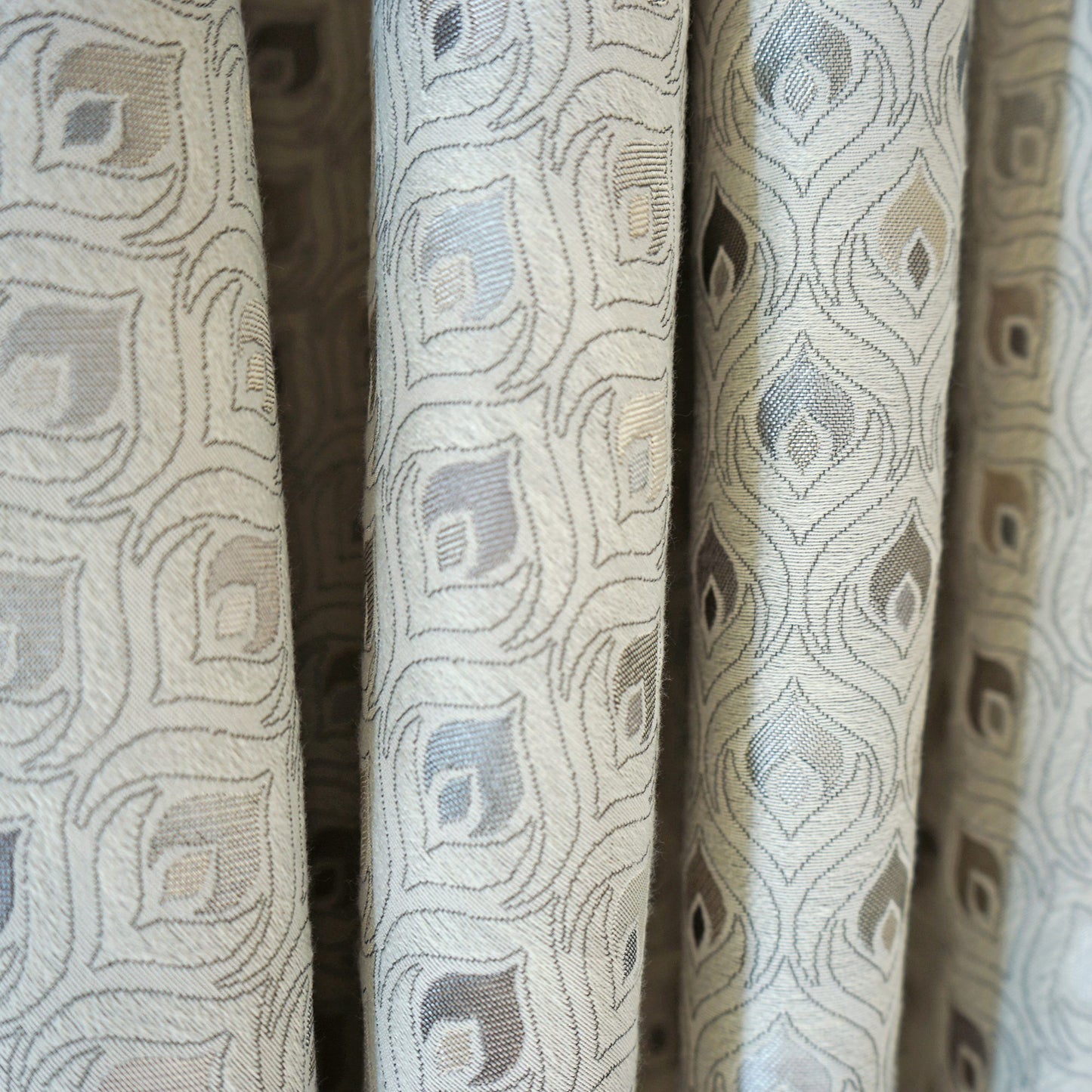 Woven jacquard fabric with pale blue & taupe diamond motifs on beige; versatile curtain or upholstery textile.