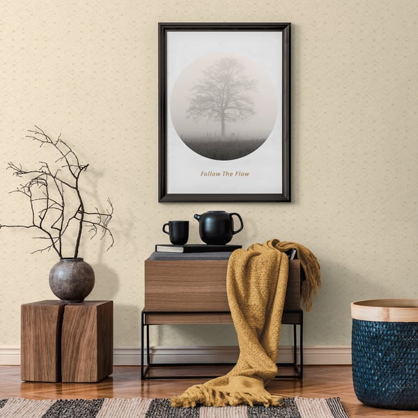 Framed circular tree art above a wooden console with black teapot, cups, mustard throw, bare-branch vase, and blue basket.