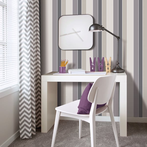 White desk and chair with a modern look, striped gray wall, black adjustable lamp, rounded square clock, purple organizers.
